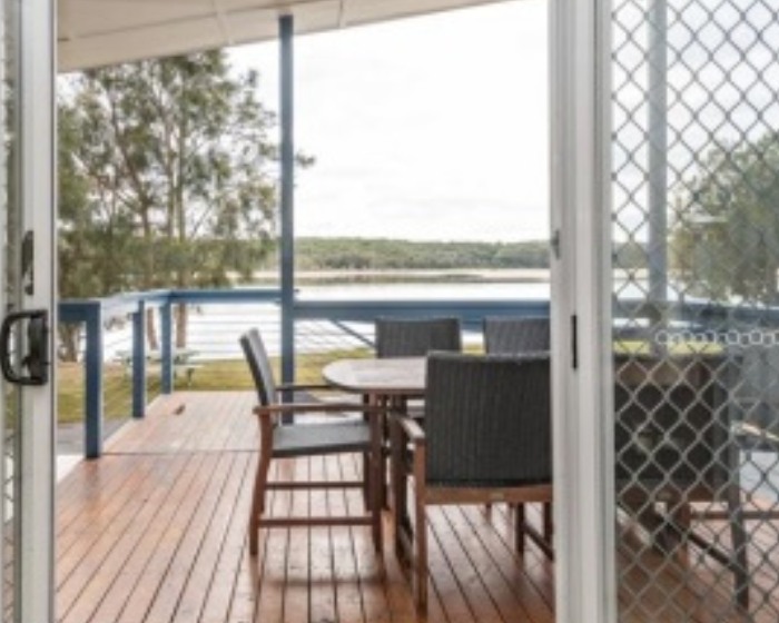 Timber deck with outdoor chairs looking across the lake at Lake Conjola