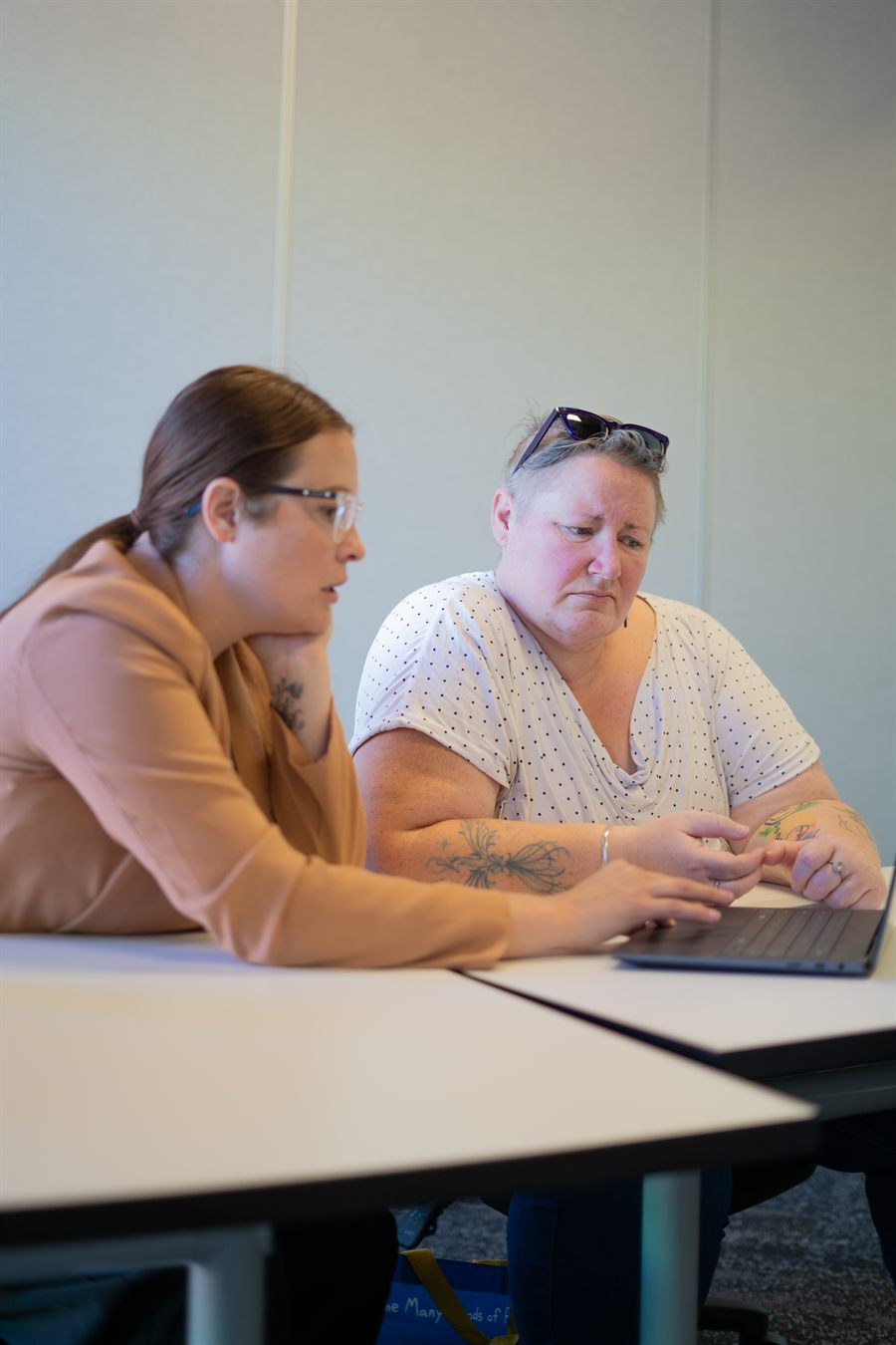Two Connect Us Care coordinators working through a plan together at a laptop